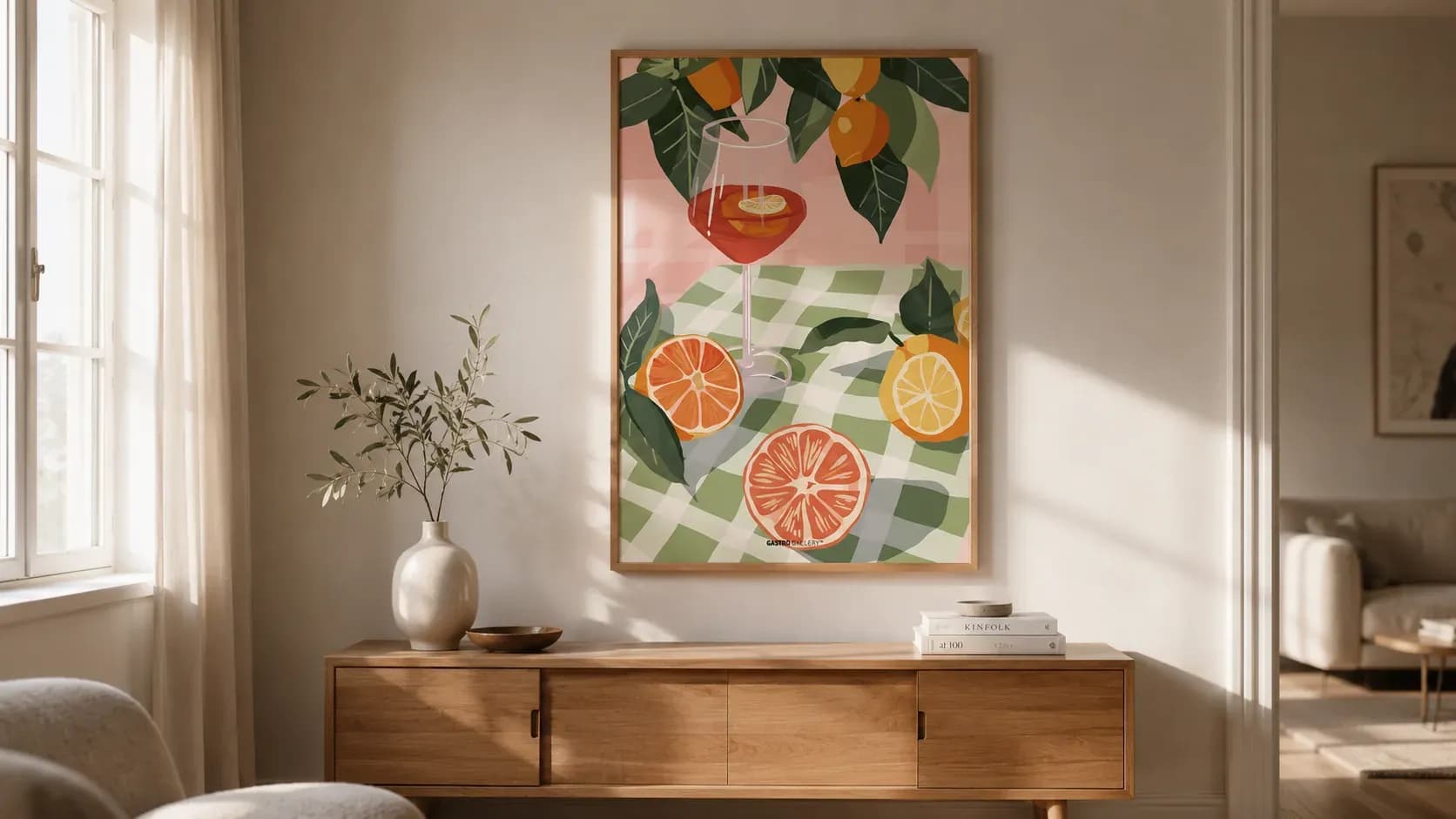 A framed citrus print above a wooden sideboard in daylight